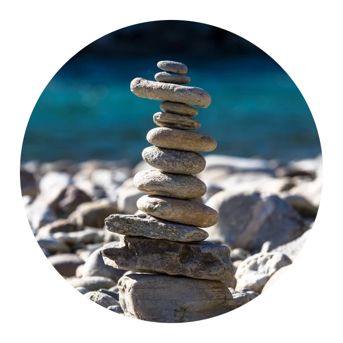 Una serena escena de playa que muestra una pila equilibrada de rocas, creando una atmósfera armoniosa y pacífica.